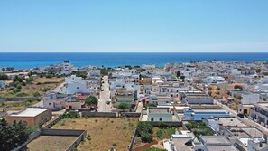 Un quartier résidentiel situé sur la côte, caractérisé par des logements compacts, une vue dégagée sur la mer et une route qui traverse le quartier.