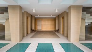 A hotel lobby with a central corridor, a reception desk, and a pool area. - Suite Giudecca in Gallipoli (Gallipoli)