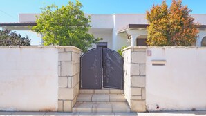 A gated entrance with a stone wall, a metal gate, and a mailbox. - Villa Fede - 3 Bedrooms 2 Bathrooms air Conditioning by the sea (Taviano)