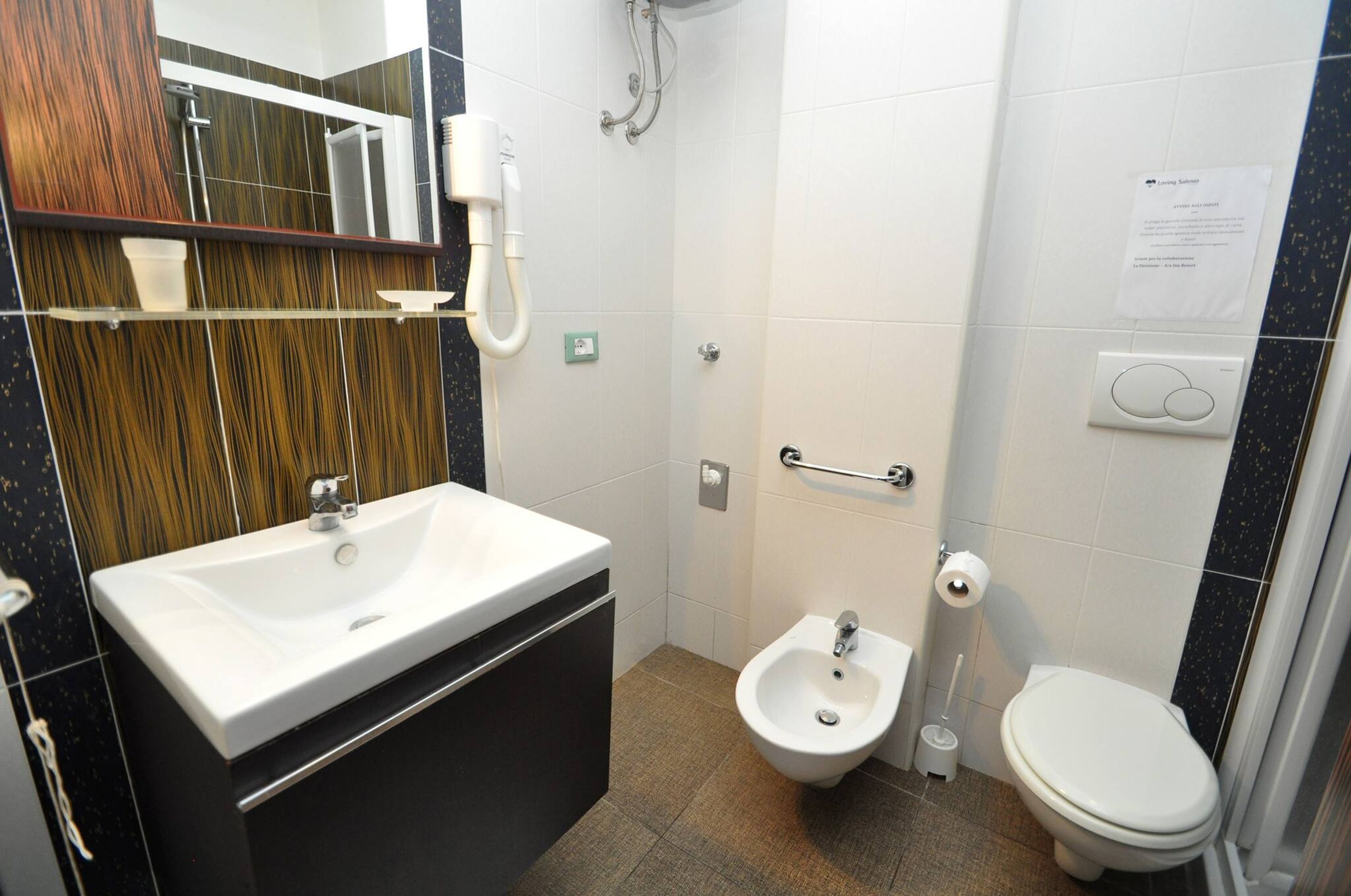 A bathroom with a white sink, bidet, and toilet.