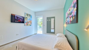 Una habitación de hotel con una cama, un televisor y dos cuadros.