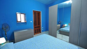 A bedroom with a bed, a wardrobe, a mirror, and a door. - Villa for 6 People 2 Bedrooms a few Meters From the sea (Ugento)