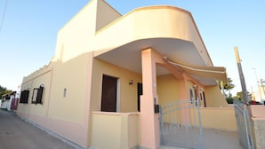 A modern two-story building with a curved facade, a gated entrance, and a small porch area. - Villa for 6 People 2 Bedrooms a few Meters From the sea (Ugento)