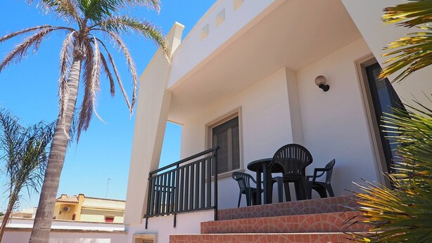 A white building with a balcony, a door, and a window. - Villetta Torre Suda 1 (Racale)