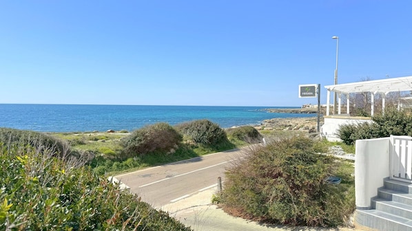 A coastal road leading to a beach with a sign reading "FRISARA". - Villetta Charme 2 in Capilungo 5 Guests by the sea (Alliste)