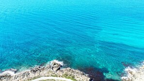 A coastal landscape with clear turquoise waters and rocky terrain. - Villetta Charme 2 in Capilungo 5 Guests by the sea (Alliste)