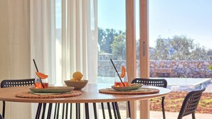A round wooden table with two chairs, each with a bowl containing a drink and an orange slice, and a plate with a lemon half. - Tenuta Alle Macchie in Racale (Racale)