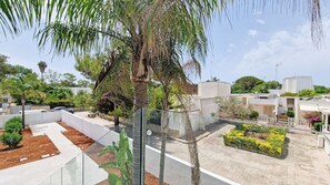 Il s’agit d’un quartier résidentiel à l’architecture moderne, qui comprend un mélange de bâtiments à toit plat et de quelques immeubles de grande hauteur. On y trouve également un jardin bien entretenu, avec diverses plantes et un chemin pavé.
