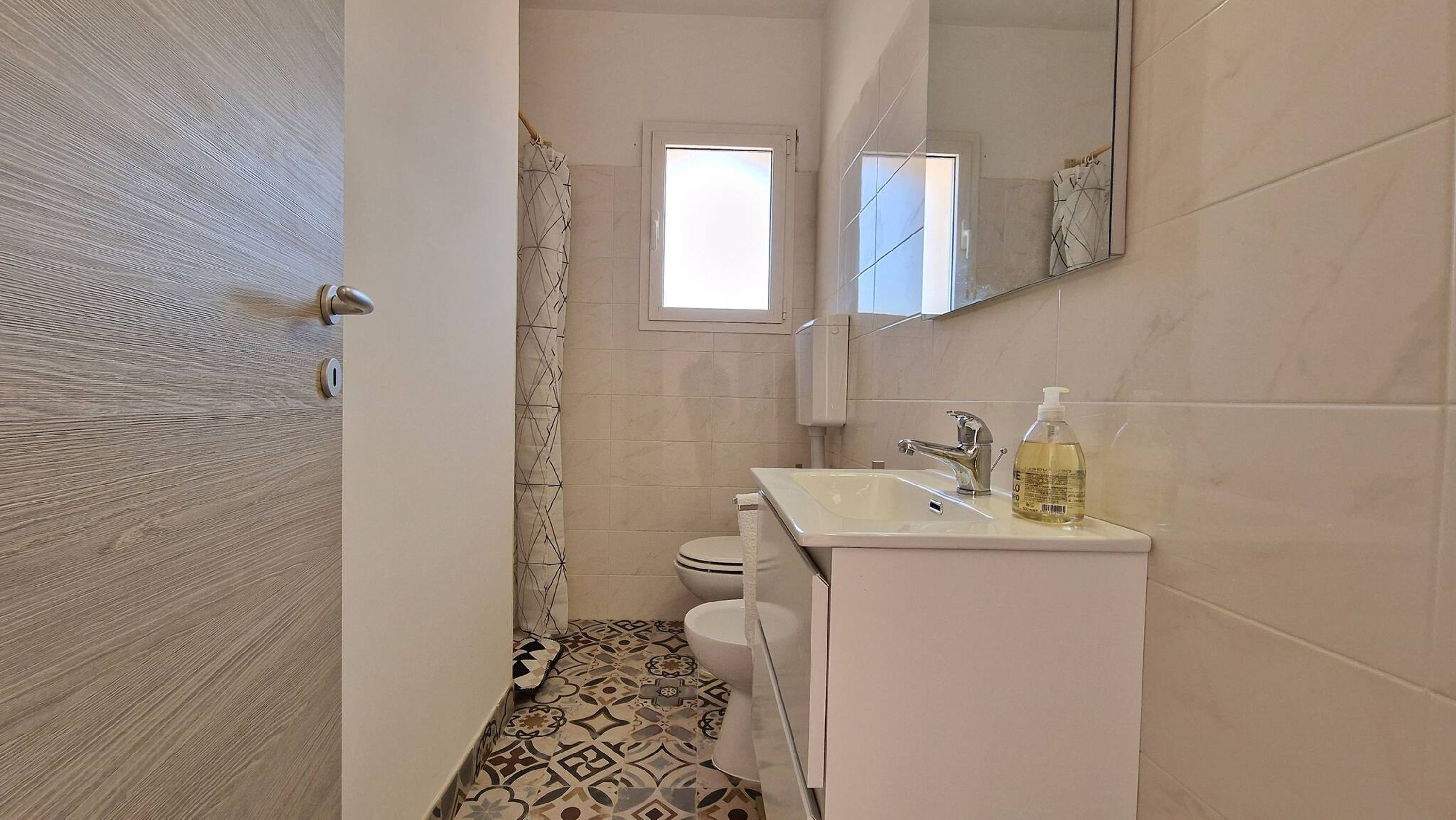 Une salle de bain avec des toilettes, un lavabo et un miroir.