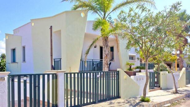A modern two-story building with a flat roof, a balcony, and a gated entrance. - Appartamento Torre Suda 2 (Racale)