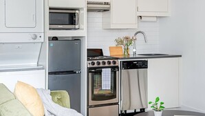 A compact kitchen with a refrigerator, microwave, stove, oven, and dishwasher.