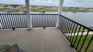 Un balcon avec vue sur un lac et les maisons environnantes.