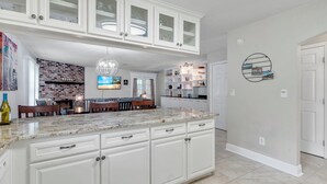 A spacious kitchen with white cabinetry, a granite countertop, and a brick backsplash. - Cozy 3BR townhome 5 minutes from downtown and Cascades (Tallahassee)