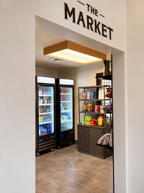 A small market area with two refrigerated display cases and a shelf stocked with snacks and beverages. - The Parkman - Great Smoky Mountains (Townsend)