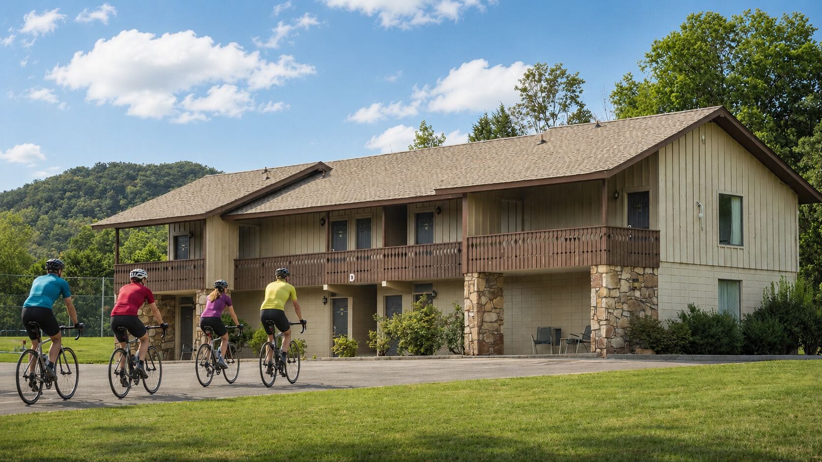 A two-story building with a balcony, stone pillars, and a paved driveway.