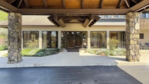 A covered entrance with stone pillars, large windows, and a wooden ceiling. - The Parkman - Great Smoky Mountains (Townsend)
