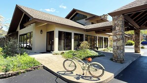 A modern two-story house with a covered porch, large windows, and a bicycle parked outside.