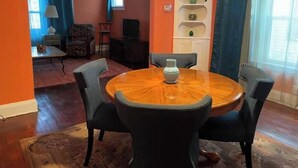 Ein Essbereich mit einem runden Tisch, vier Stühlen und einer Vase.