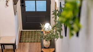 A staircase leading to a door with a view of the sky, a bench, a plant, and a basket on the landing. - Cozy home near Med Center, NRG, UH, Downtown, Museum (Houston)