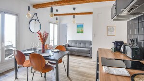 Una cocina moderna con comedor, vigas de madera y vista a la ciudad.