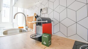 Cocina de diseño moderno con lavamanos, cafetera y una cesta de bienvenida.