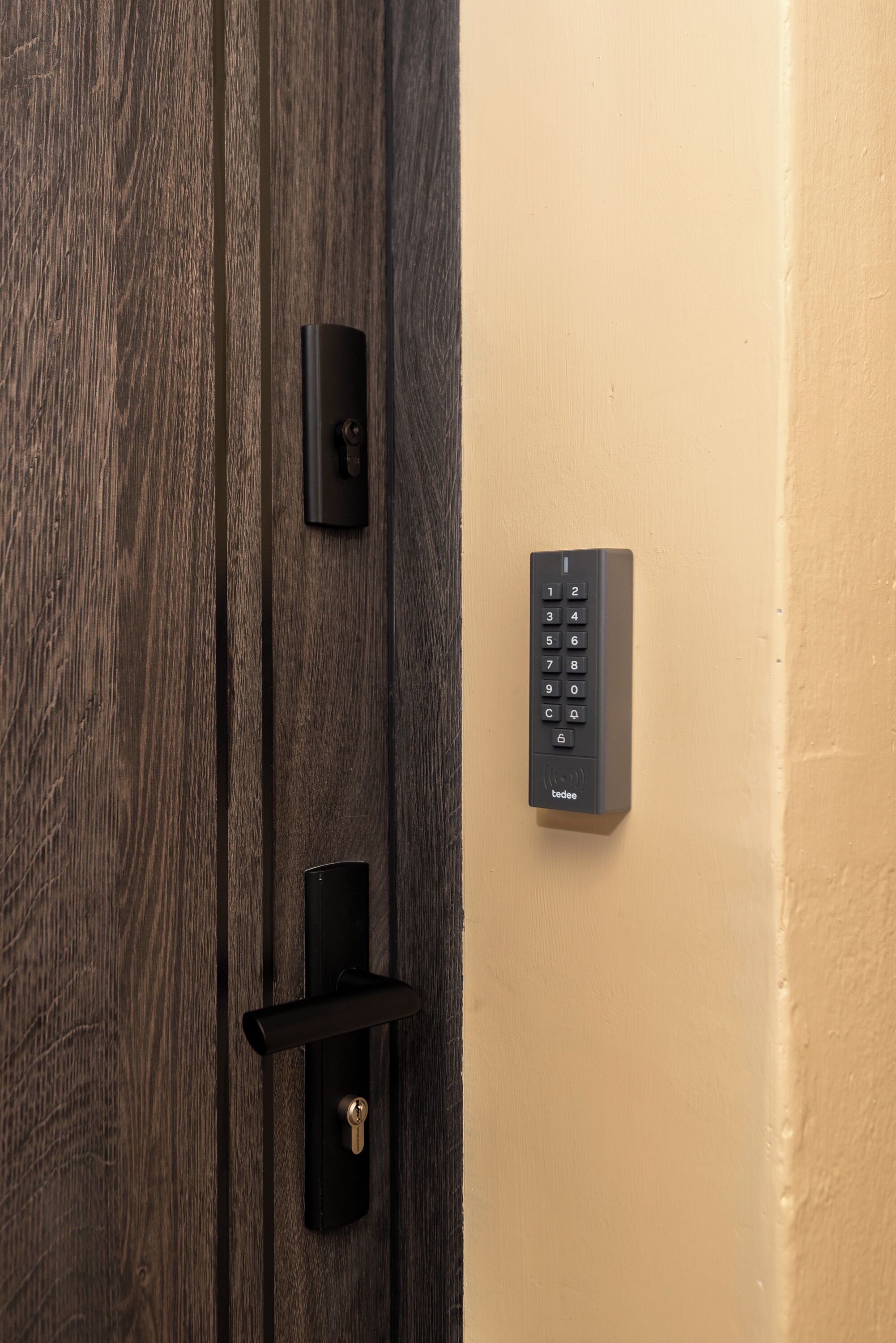 A door with a keypad lock and a keyhole.