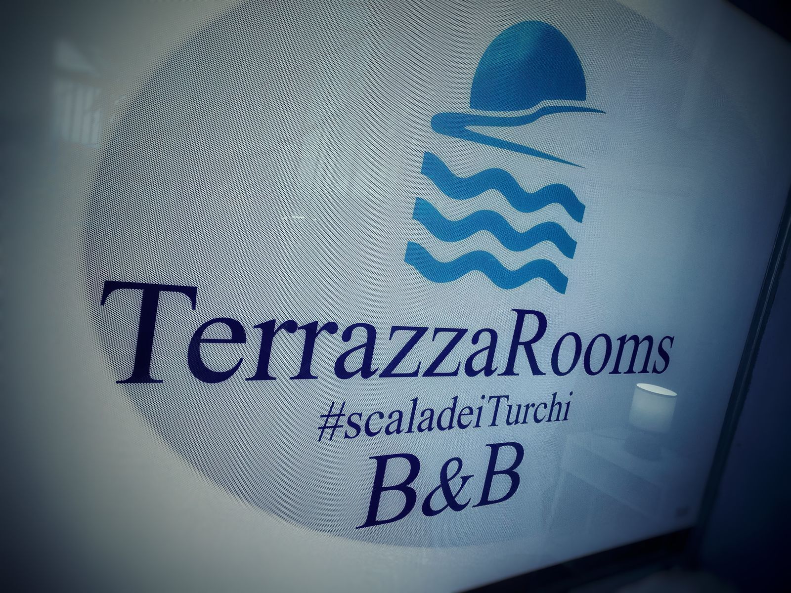 A logo with the text "TerrazzaRooms" and a hashtag "#scaladeiTurchi".