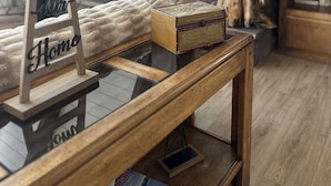 Un dormitorio estilo loft acogedor con techo inclinado, una decoración de molino, una escultura de caballo, una estantería y una cama mullida.