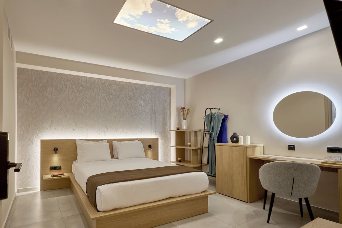 Quarto moderno com cama, escrivaninha, cadeira e claraboia.