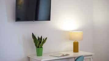 Kamar Quadruple Deluks, pemandangan laut | Brankas, meja kerja, ruang kerja ramah laptop, dan tirai kedap cahaya