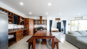 Une cuisine moderne avec des meubles en bois, un plan de travail en marbre et une table à manger.
