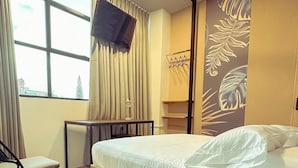 A hotel room with a bed, a desk, a chair, a ceiling fan, and a TV mounted on the wall. - Hotel Star 37 Av (Ibague)