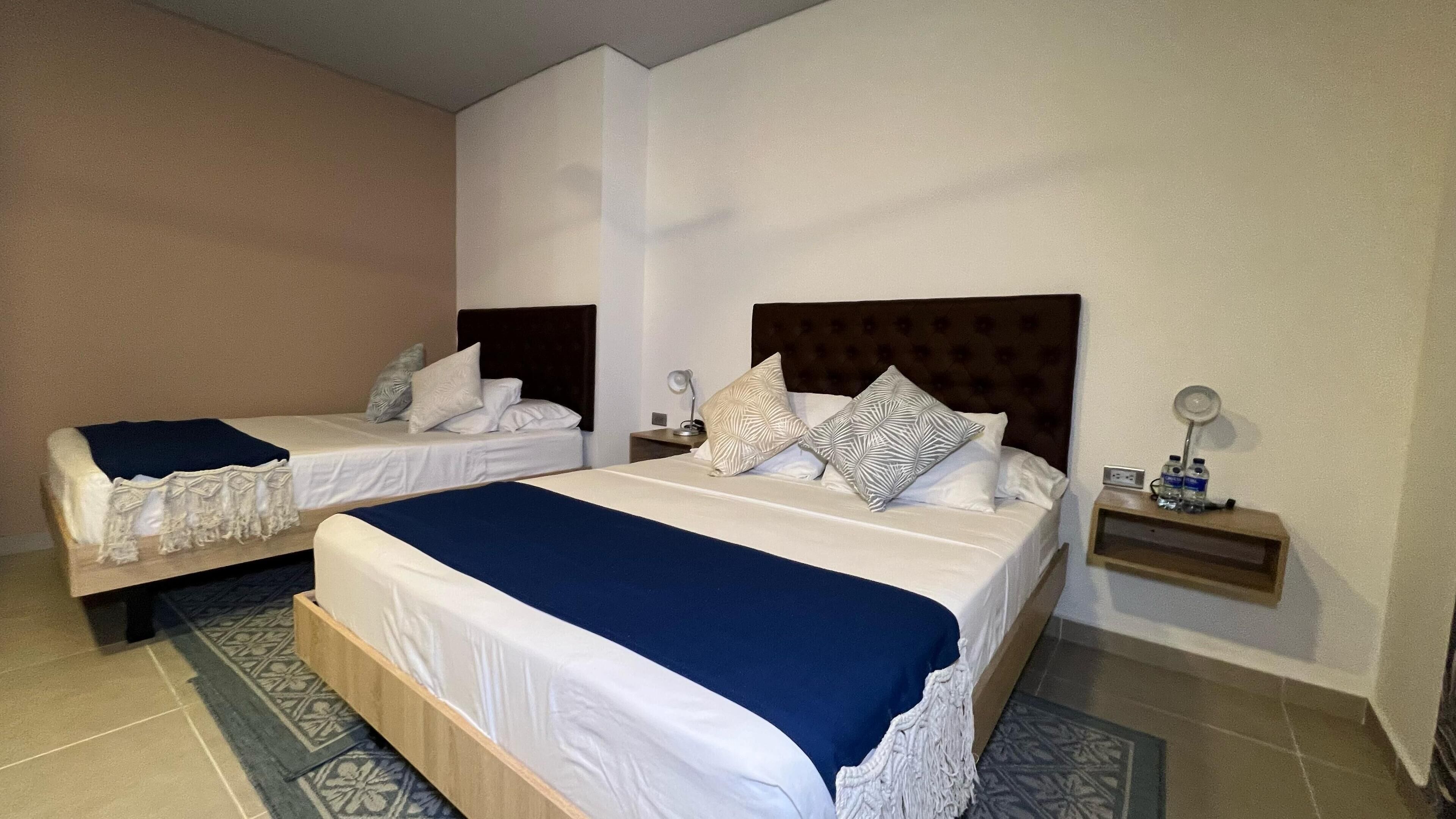 Two single beds with headboards, bedside tables with lamps, and a patterned rug.