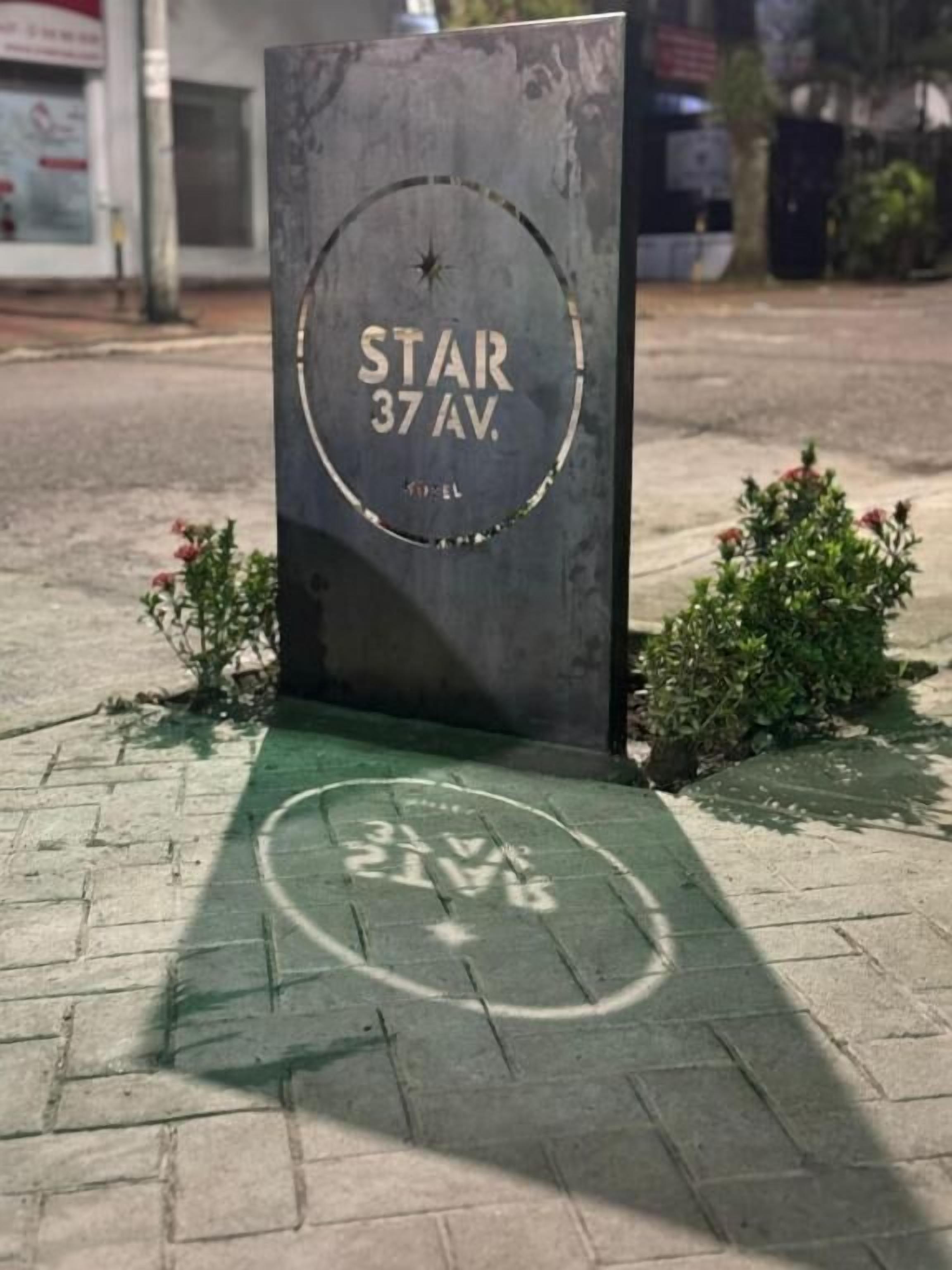 A metal sign with "STAR 37 AV." and a circular emblem.
