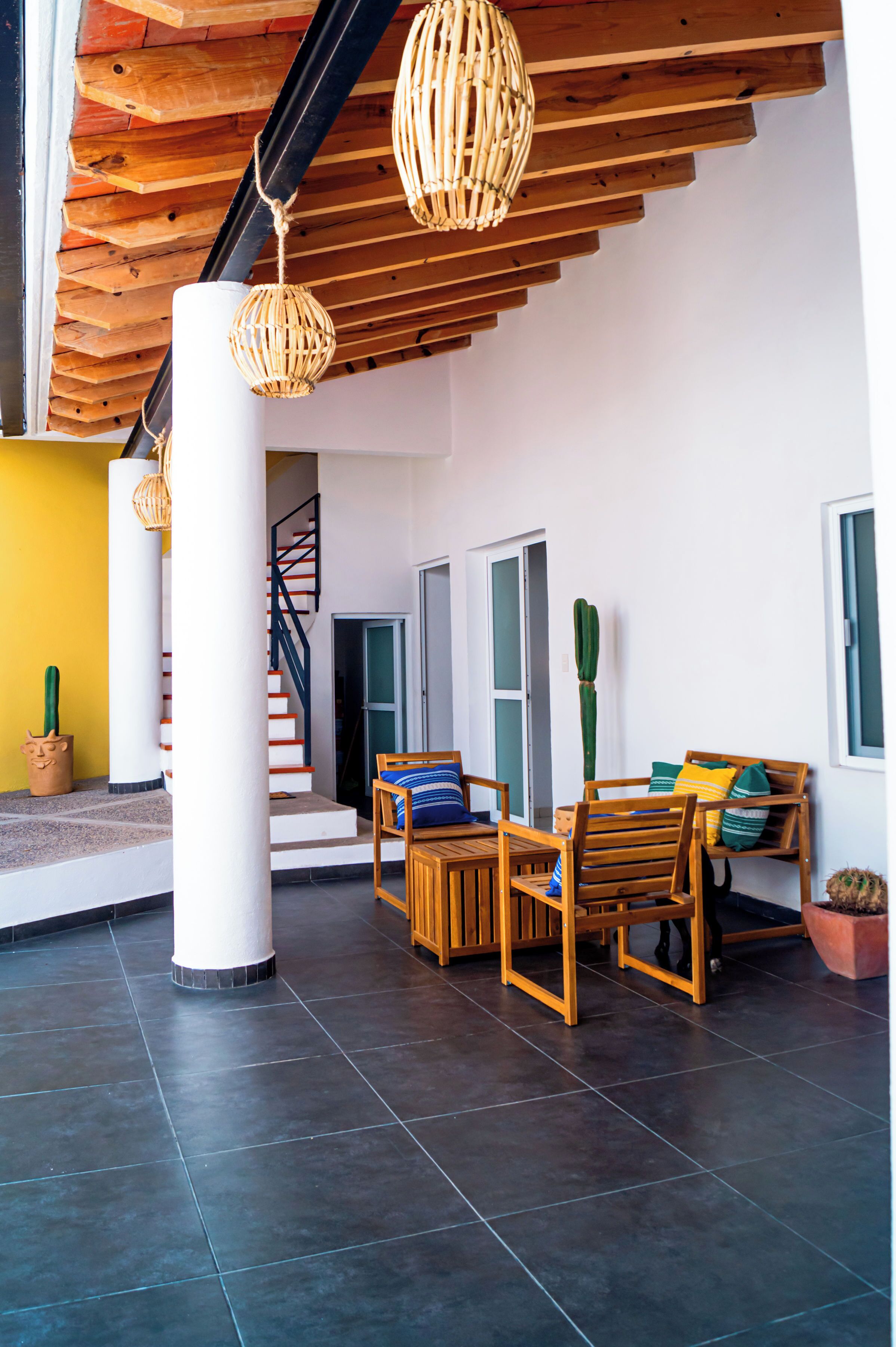 A modern interior with a wooden ceiling, a staircase, and a seating area with a table and chairs.
