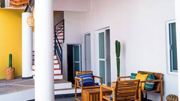 A modern interior with a wooden ceiling, a staircase, and a seating area with a table and chairs.