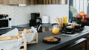 Eine Küchenarbeitsplatte mit Brot, Keksen, einer Obstschale und einer Kaffeemaschine.