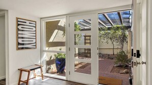 A room with a sliding glass door leading to an outdoor patio. - Desert Luxe: 3BR W/Pools, Tennis (Tucson)