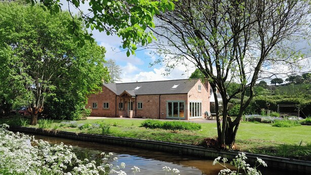 A brick house with a large window and a covered porch. - Canal-side 5-bed Cottage - Sleeps 10, Pet Friendly (Stoke-on-Trent)