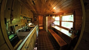 Cocina compacta con armarios de madera, un lavamanos y una estufa.