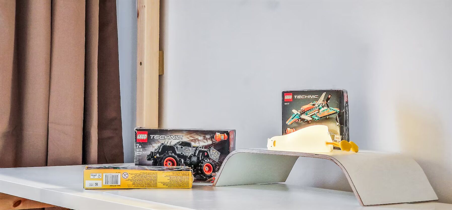 Et bord med LEGO TECHNIC kasser og en lille flymodel.