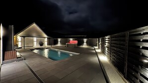 A rooftop pool area with a hot tub, seating, and a covered patio. - Relax in the pool, whirlpool, sauna or wood-fired hot tub. (Neubörger)