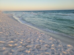 A beach with a sandy shore and gentle waves.