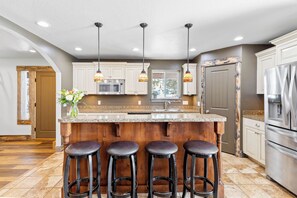 A kitchen with a central island, bar stools, a microwave, a sink, and pendant lighting. - Large house with lots of space. Just minutes away from national forest. (Thayne)