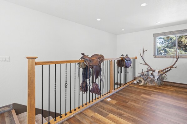 A staircase with wooden railings and a deer head sculpture at the top. - Large house with lots of space. Just minutes away from national forest. (Thayne)