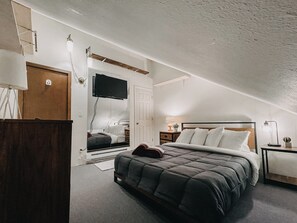 A bedroom with a bed, a dresser, a TV mounted on the wall, and a door. - 73sw - A Perfect Family Getaway! Wifi, Great Resort Amenities (Deming)