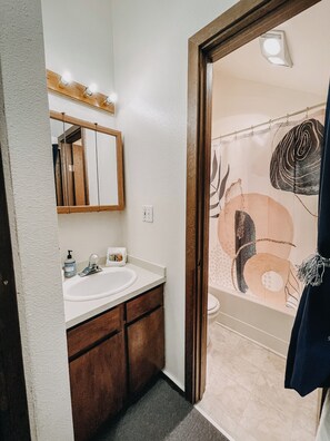 A bathroom with a white sink, wooden vanity, and a mirror with lights above. - 73sw - A Perfect Family Getaway! Wifi, Great Resort Amenities (Deming)