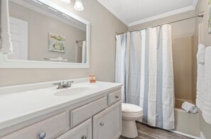 A bathroom with a white sink, a mirror, a toilet, and a shower curtain. - Charming 2-bedroom condo in desirable Sandestin Resort, GOLF CART INCLUDED!! (Destin)