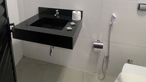 A bathroom with a black sink, a toilet, a shower, and a towel rack. - ADD HOTÉIS Congonhas (Sao Paulo)