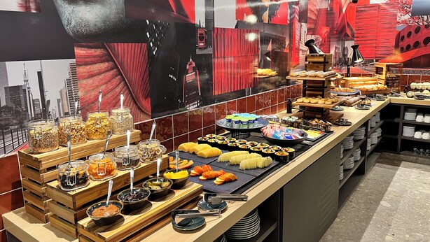A buffet with various food items and condiments, including fruits, vegetables, and pastries. - Radisson RED Ibirapuera (Sao Paulo)
